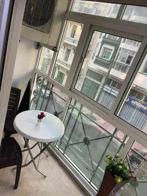 a white table and chairs in a room with windows at Lovely place in Casablanca