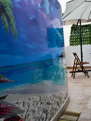 a mural of a beach with a chair and an umbrella at Modern, Fully Equipped Studio Just Steps from Mohammed 5 Stadium, Maarif in Casablanca