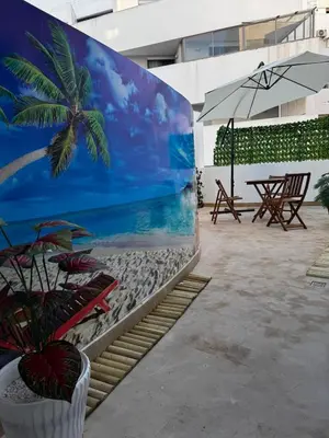 a mural of a beach with a palm tree at Modern, Fully Equipped Studio Just Steps from Mohammed 5 Stadium, Maarif in Casablanca