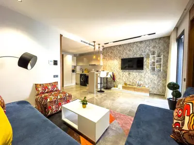 a living room with a couch and a table at Modern, Fully Equipped Studio Just Steps from Mohammed 5 Stadium, Maarif in Casablanca