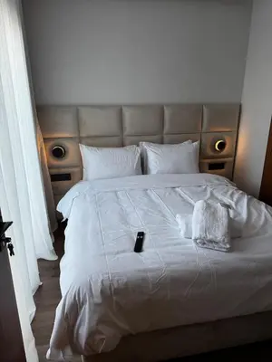 a large white bed with a remote control on it at Modern, Fully Equipped Studio Just Steps from Mohammed 5 Stadium, Maarif in Casablanca