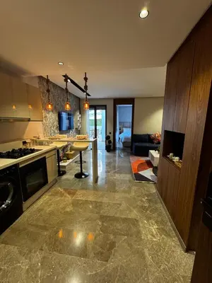 a large kitchen with a counter and a living room at Modern, Fully Equipped Studio Just Steps from Mohammed 5 Stadium, Maarif in Casablanca