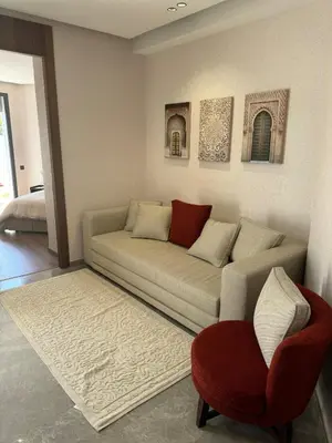 a living room with a couch and a red chair at Modern, Fully Equipped Studio Close to Mohamed 5 Stadium - Maarif in Casablanca
