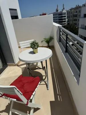 a white table and chairs on a balcony at Modern, Fully Equipped Studio Close to Mohamed 5 Stadium - Maarif in Casablanca