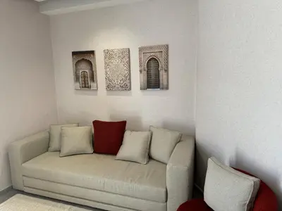 a couch in a room with three pictures on the wall at Modern, Fully Equipped Studio Close to Mohamed 5 Stadium - Maarif in Casablanca