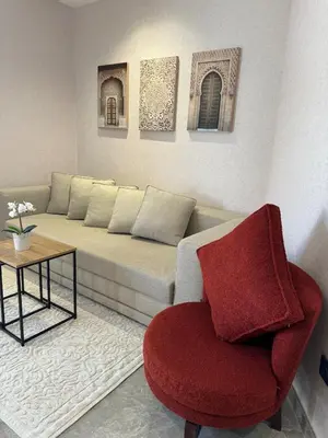 a living room with a couch and a red chair at Modern, Fully Equipped Studio Close to Mohamed 5 Stadium - Maarif in Casablanca
