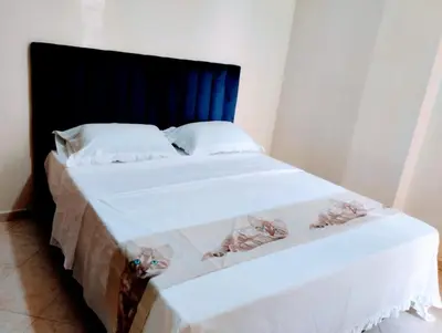 a bed with white sheets and a blue headboard at Appartament a 2 minute de la mer et la mosquee Hassan 2 in Casablanca-Port