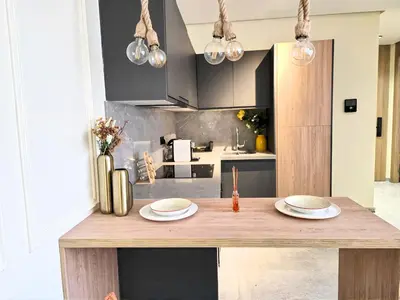 a kitchen with a wooden table with two plates on it at Casablanca METROPOL Suites in Casablanca