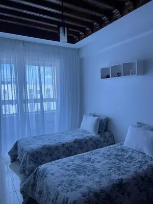 two beds in a room with blue lights at Athènes résidence in Océan