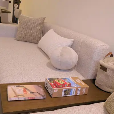a couch with two books on a coffee table at ORA Luxoria Suite Racine & Gym by Staycationcasa in Casablanca-Port