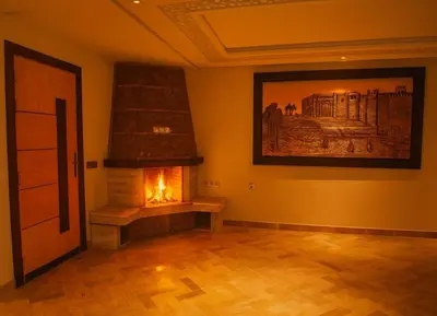 a room with a fireplace and a painting on the wall at Résidence Macha'allah in O Ben Slimane