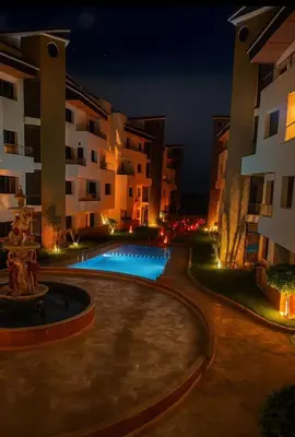 a swimming pool in front of a building at night at Résidence Macha'allah in O Ben Slimane