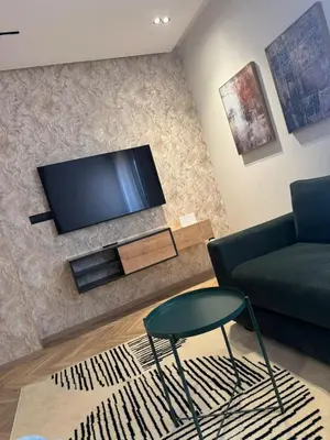 a living room with a couch and a tv on a wall at Selena Modern Studio with Quick Access to Tramway near to Mohamed 5 Stadium in Casablanca in Casablanca