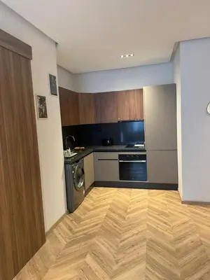 a kitchen with wooden floors and a washer and dryer at Selena Modern Studio with Quick Access to Tramway near to Mohamed 5 Stadium in Casablanca in Casablanca