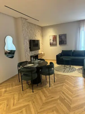 a living room with a table and a blue couch at Selena Modern Studio with Quick Access to Tramway near to Mohamed 5 Stadium in Casablanca in Casablanca