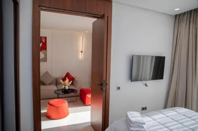a bedroom with a bed and a television and a room with a couch at Peaceful Haven for a Quiet Stay in Maarif 500m to Mohamed Stadium in Casablanca