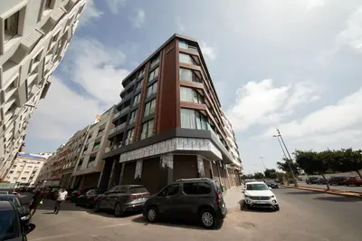 a tall building with cars parked in front of it at SALVia Loft - Sweetness and Cozy Apartment with Terrace Near Mohammed V Stadium in Casablanca