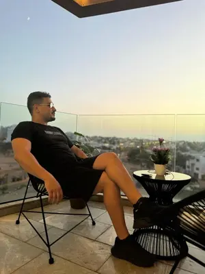 a man sitting in a chair on a balcony at HERBA Studio - Cozy Space with an Unobstructed View in Bourgogne in Casablanca