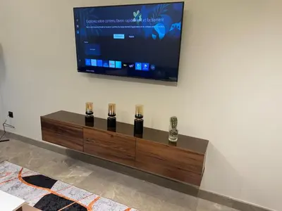 a television on a wall with five bottles on it at HERBA Studio - Cozy Space with an Unobstructed View in Bourgogne in Casablanca
