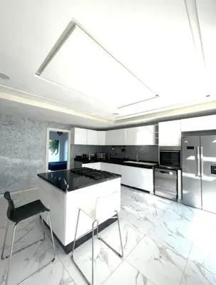 a large white kitchen with a large skylight at Villa Sophia in Dar Bouazza