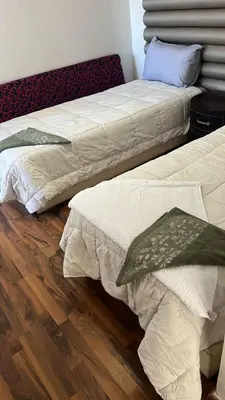 two beds sitting next to each other on a wooden floor at seaside entire villa with pool view in Casablanca