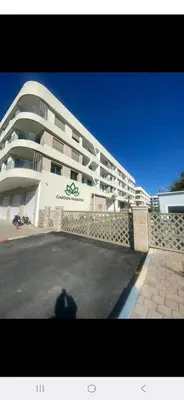a large white building with a person in front of it at appartement résidence garden paradise plage bouznika in Bouznika