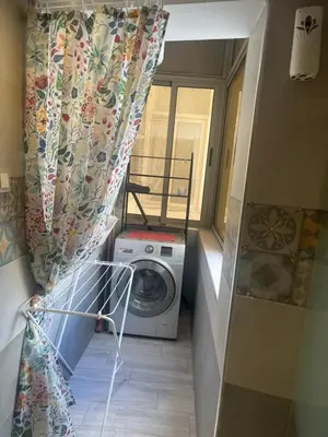 a laundry room with a washing machine and a curtain at Toute commodité in Casablanca