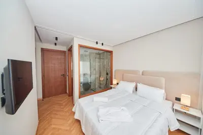 a bedroom with a white bed and a television at Marilla Studio - Elegant & Peaceful Stay in Bourgogne, Steps from Mohamed V Stadium in Casablanca