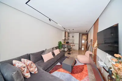 a living room with a gray couch and a kitchen at Marilla Studio - Elegant & Peaceful Stay in Bourgogne, Steps from Mohamed V Stadium in Casablanca