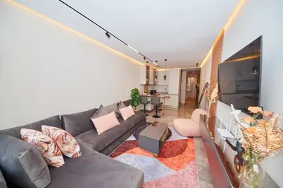 a living room with a gray couch and a tv at Marilla Studio - Elegant & Peaceful Stay in Bourgogne, Steps from Mohamed V Stadium in Casablanca