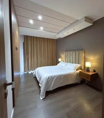 a bedroom with a large white bed and two lamps at Premium Studio Central Casablanca in Casablanca