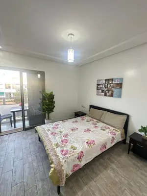 a bedroom with a bed with a floral bedspread at Appartement Marbella beach in Mansouria