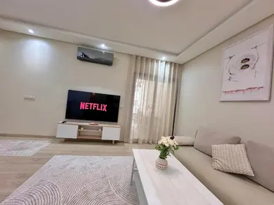 a living room with a couch and a tv at Modern Comfort Studio, la corniche in Mohammedia