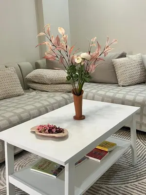 a white coffee table with a vase of flowers on it at Modern Comfort Studio, la corniche in Mohammedia