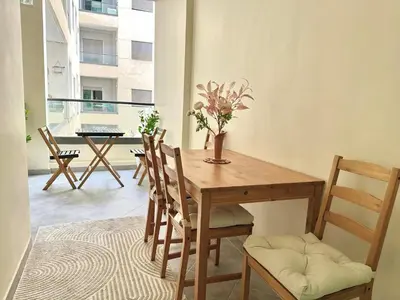 a dining room with a wooden table and chairs at Modern Comfort Studio, la corniche in Mohammedia