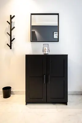 a mirror on a wall above a black cabinet at APGCI-Elegant studio sur Ferme bretonne in Casablanca