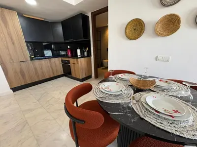 a dining room with a table with red chairs at Cosy Studio at B-Living Casa Port Ideal for Business & City Trips with Open View Heart Of Casablanca in Casablanca