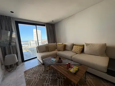 a living room with a couch and a table at Cosy Studio at B-Living Casa Port Ideal for Business & City Trips with Open View Heart Of Casablanca in Casablanca