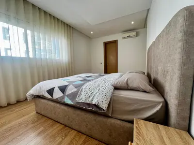 a bedroom with a large bed and a large window at Urban Chic 2BR - Prestigia near stadium in Rabat