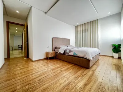 a bedroom with a bed and a wooden floor at Urban Chic 2BR - Prestigia near stadium in Rabat