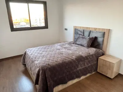 a bedroom with a large bed and a window at Appartement moderne aux perles de temara in Temara