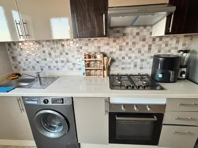 a kitchen with a stove and a washing machine at Appartement moderne aux perles de temara in Temara