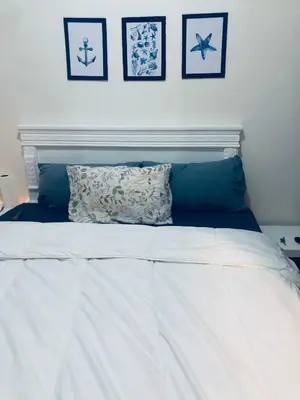 a white bed with two pillows on top of it at Chambre cosy vue sur jardin in Mohammedia