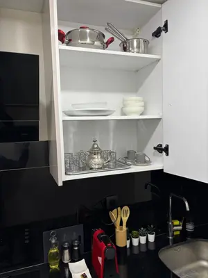 a kitchen with a sink and a shelf with dishes at Studio moderne avec Fibre Optique, 55po TV et CVC in Casablanca