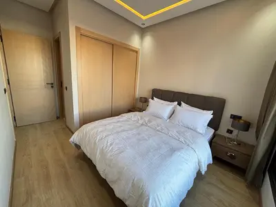 a bedroom with a large bed with white sheets at Studio moderne avec Fibre Optique, 55po TV et CVC in Casablanca