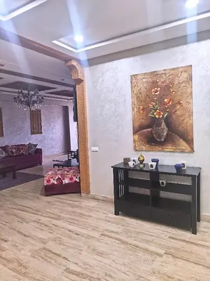 a living room with a painting of a vase of flowers at Grande appartement 4 chambre in Casablanca