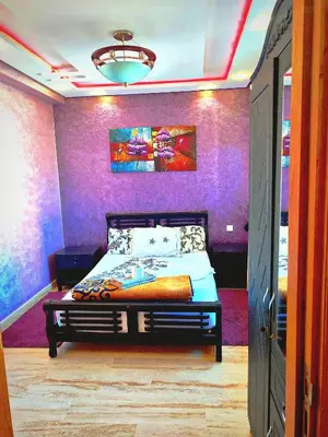a bedroom with a bed and a purple wall at Grande appartement 4 chambre in Casablanca