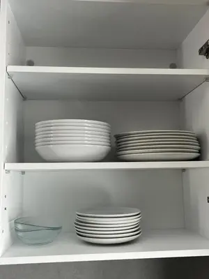 a white shelf with plates and bowls on it at Métropole parc Manesmane in Mohammedia