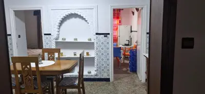 a dining room and kitchen with a table and chairs at Appartement Océan in Rabat