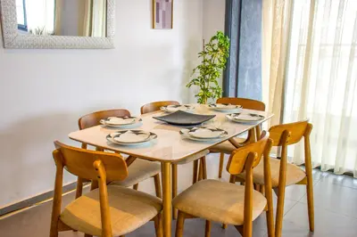 a dining room table with chairs and a wooden table at Modern Apt with sea view and access to the beach in El Harhoura